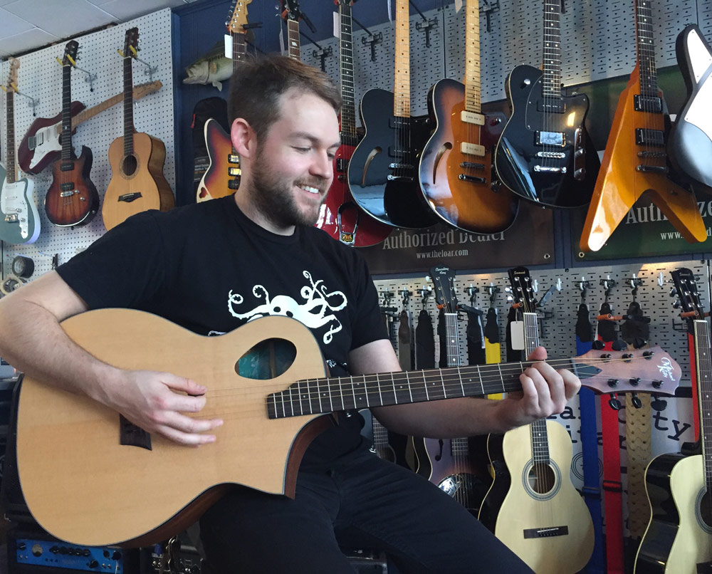 John Harney at Collar City Guitars playing a Michael Kelly Acoustic Port guitar