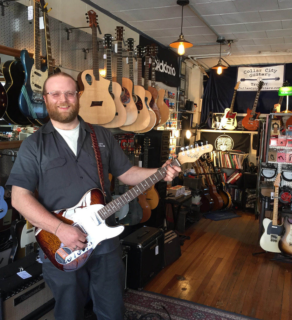 Peter G. Fisher at CCG holding a Michael Kelly 1950 electric guitar in Caramel Burst