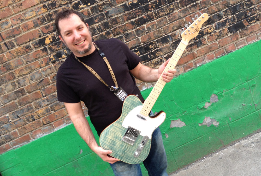Steve's Music staff holding a Michael Kelly 1950s electric guitar