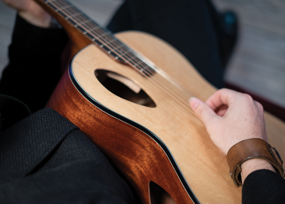 hand playing acoustic guitar