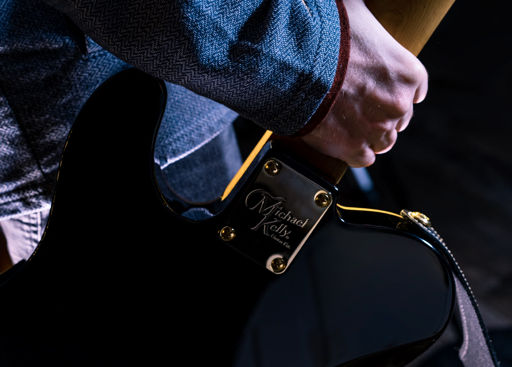 side view man playing electric guitar