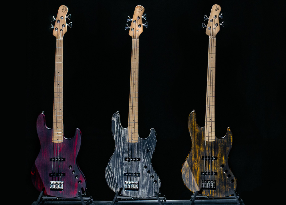 three electric basses on stands